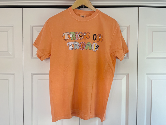 an orange tshirt hanging on a white door