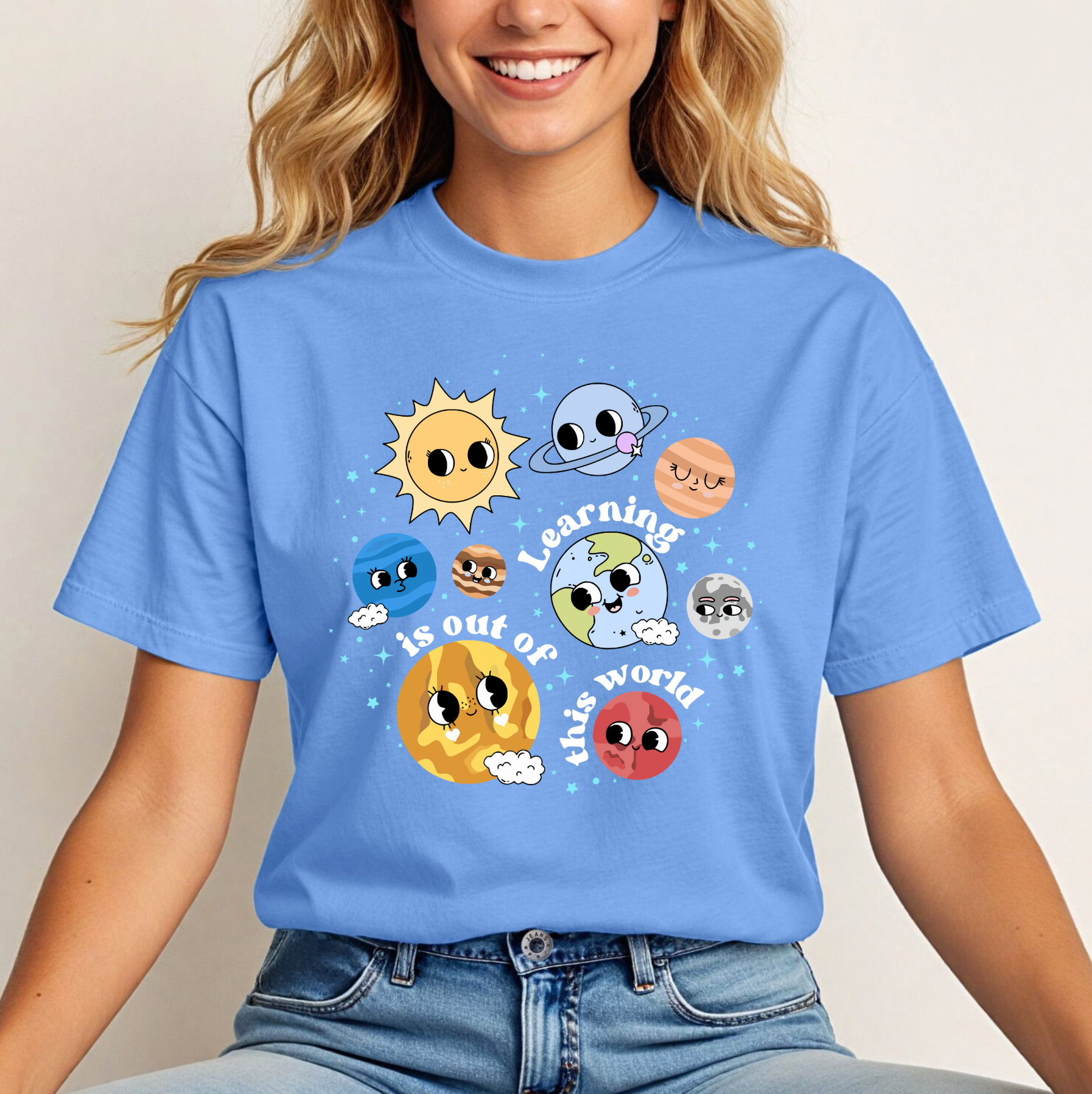 a woman wearing a blue t - shirt with cartoon faces on it