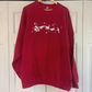 a red sweater with a white design on it