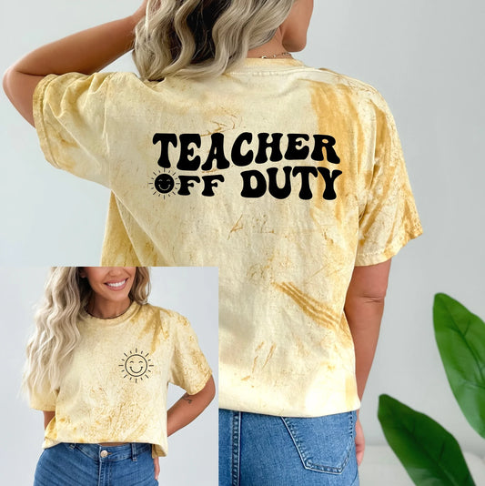 a woman wearing a yellow teacher of duty shirt