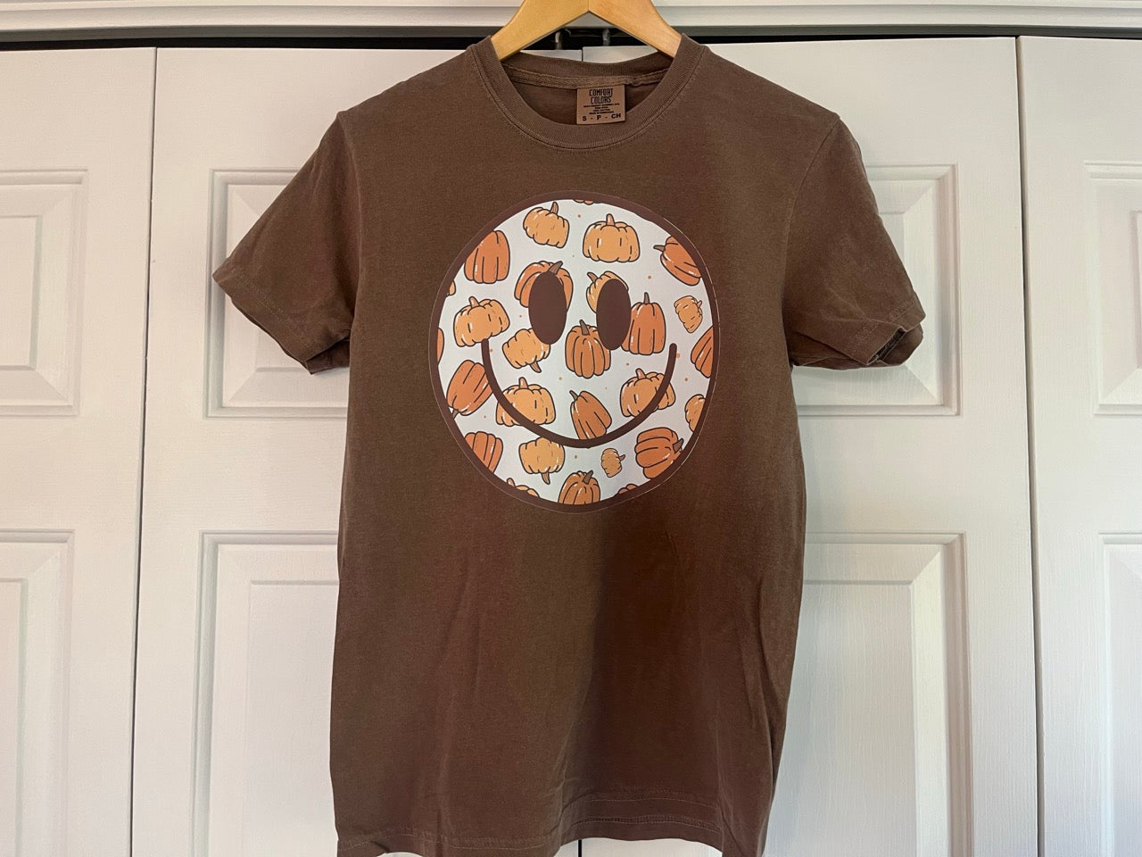 a brown shirt with a smiley face drawn on it