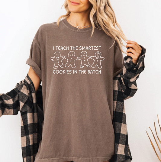 a woman wearing a brown shirt that says i teach the smartest cookies in the