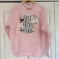 a pink sweatshirt hanging on a white door