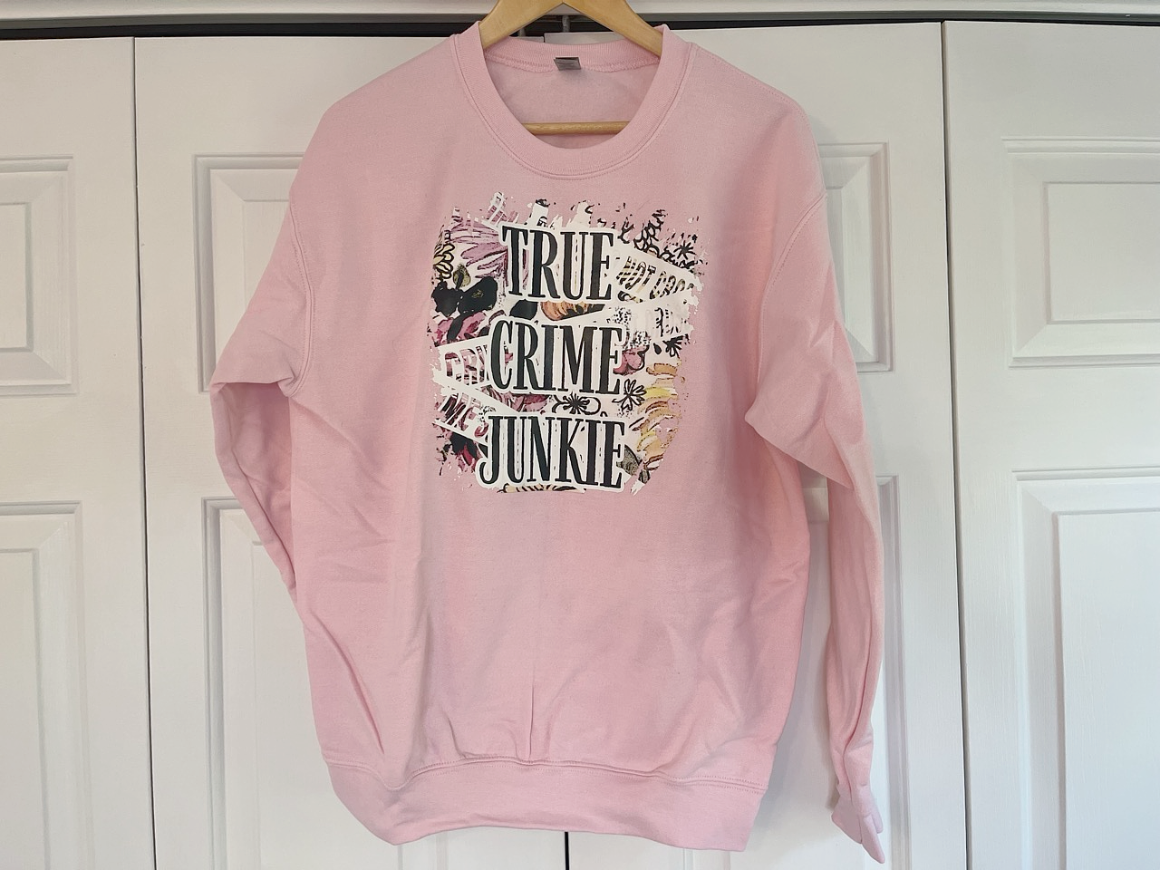 a pink sweatshirt hanging on a white door