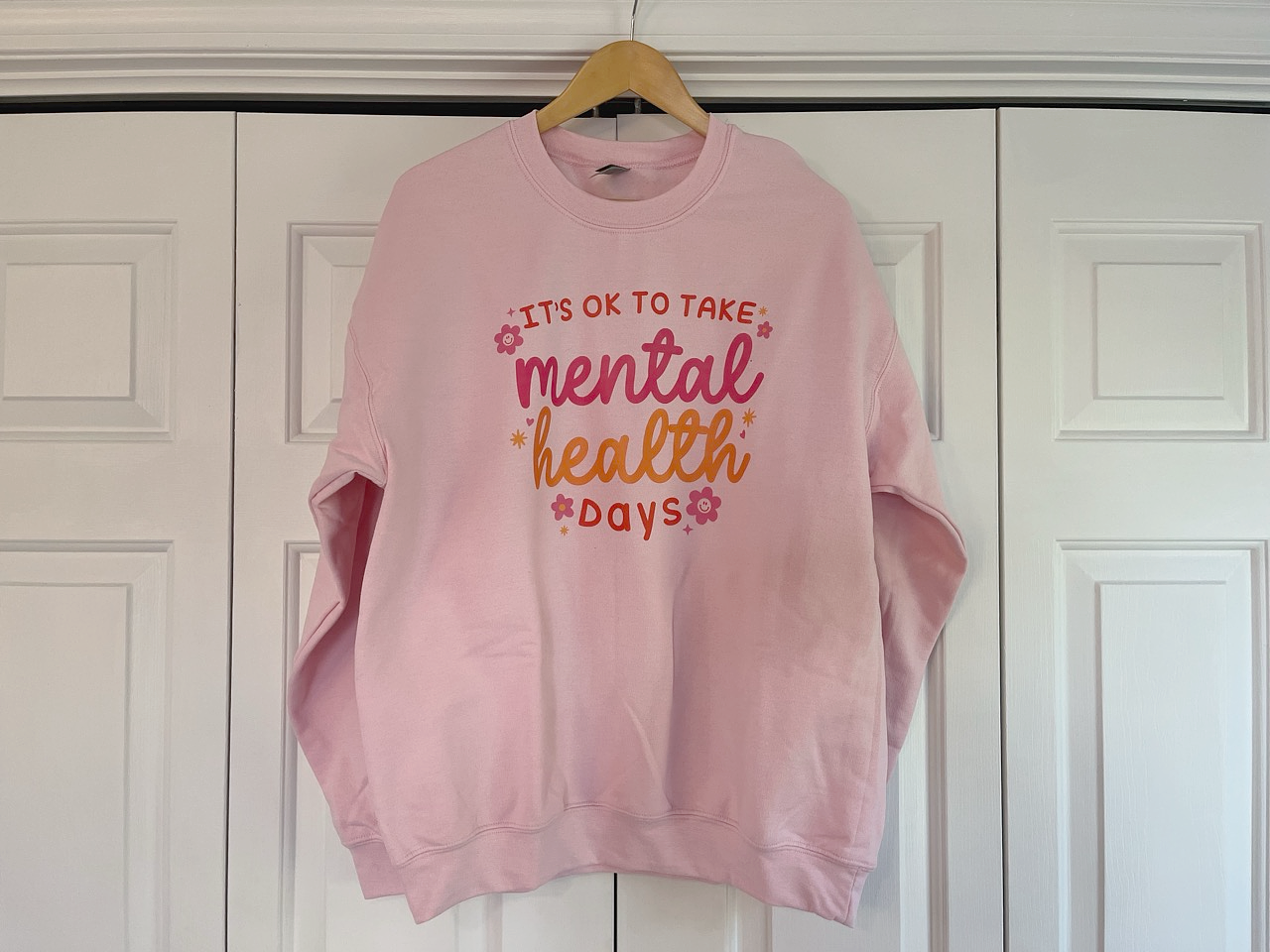 a pink sweatshirt that says it's ok to take mental health days