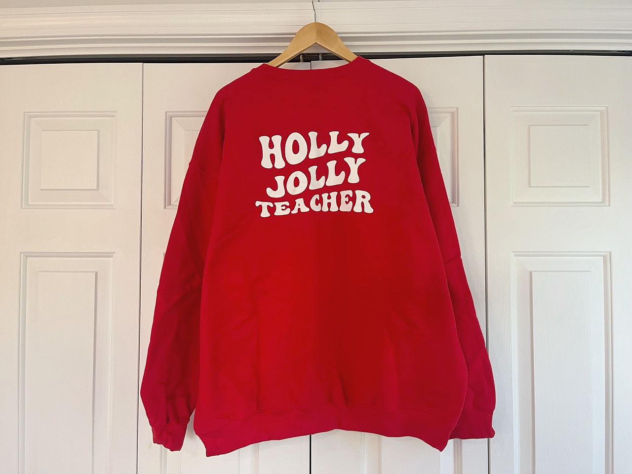 a red sweatshirt hanging on a white door