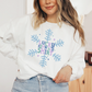 a woman wearing a white sweatshirt with a snowflake design