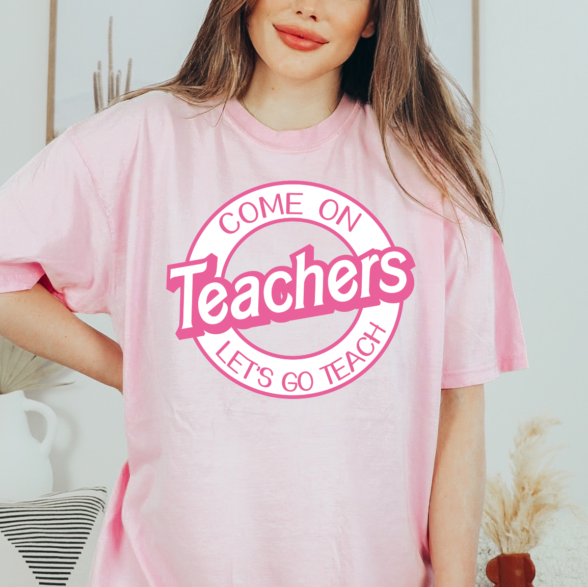 a woman wearing a pink t - shirt with the words teachers on it