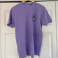 a purple shirt with a smiley face drawn on it