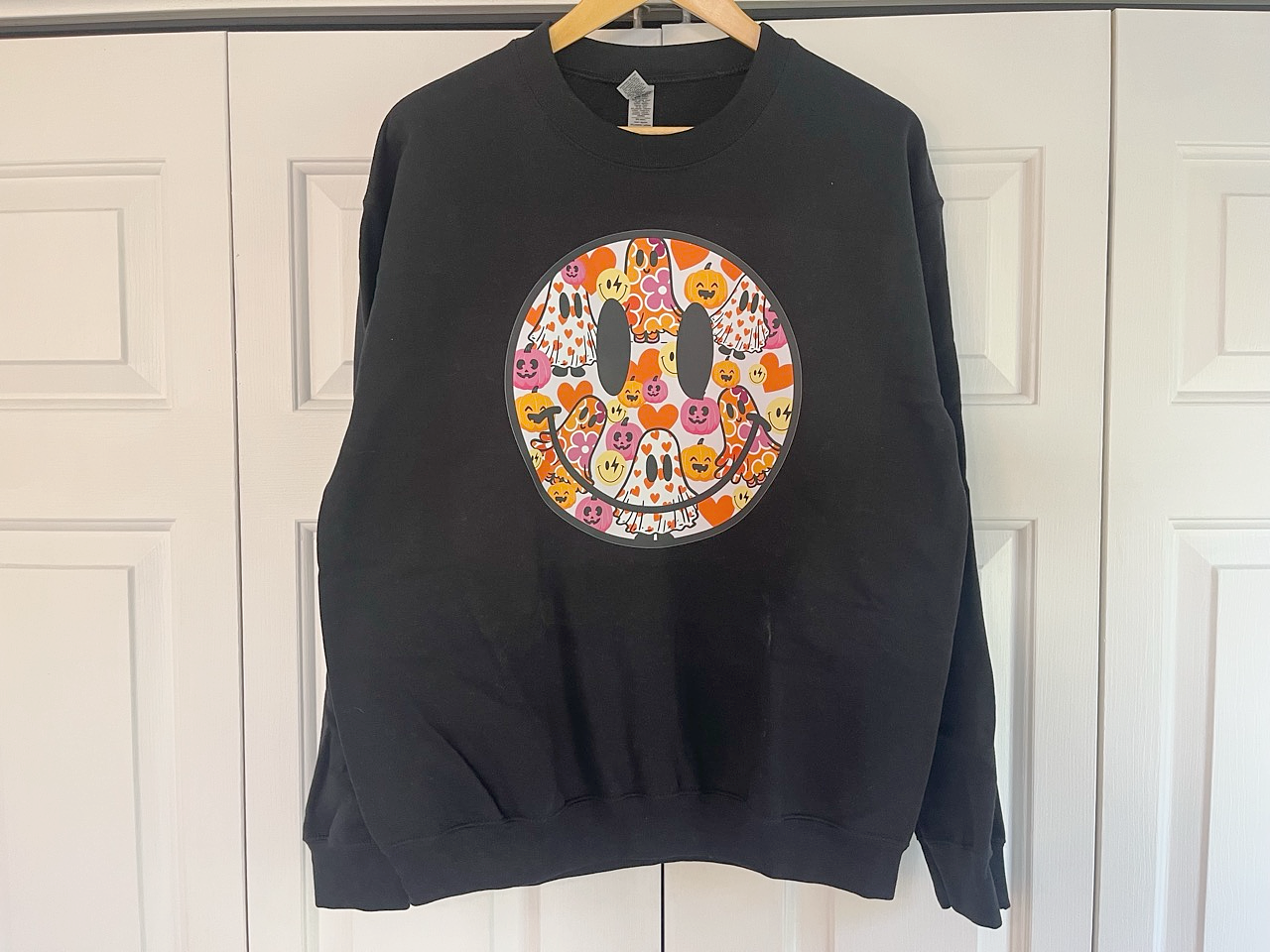 a black sweatshirt with a smiley face on it