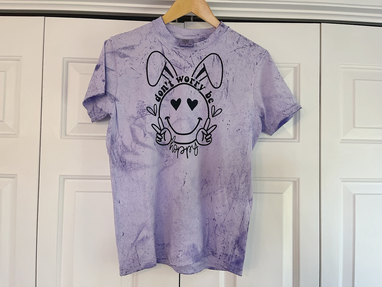 a purple t - shirt with a dog's face drawn on it