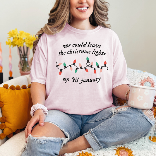 a woman sitting on a couch wearing a pink shirt