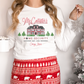 a woman wearing a christmas pajama set with a house on it