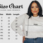 a woman wearing a size chart sweatshirt and jeans