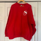 a red sweatshirt hanging on a white door